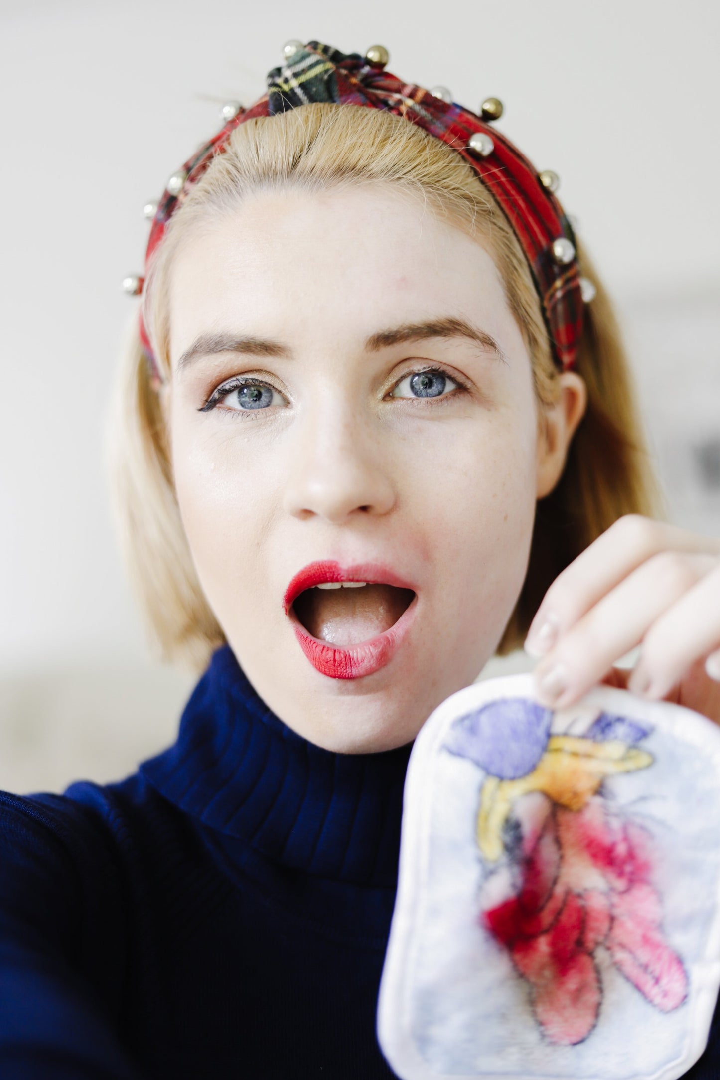 Woman holding Mickey & Friends 7-Day Set MakeUp Eraser cloth.